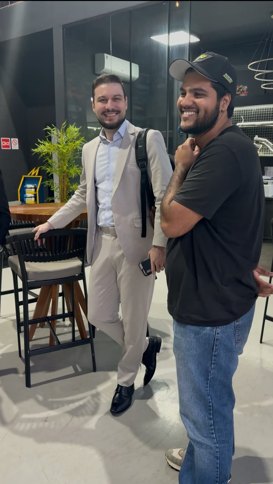 Dois empresários conversando e sorrindo em um ambiente corporativo